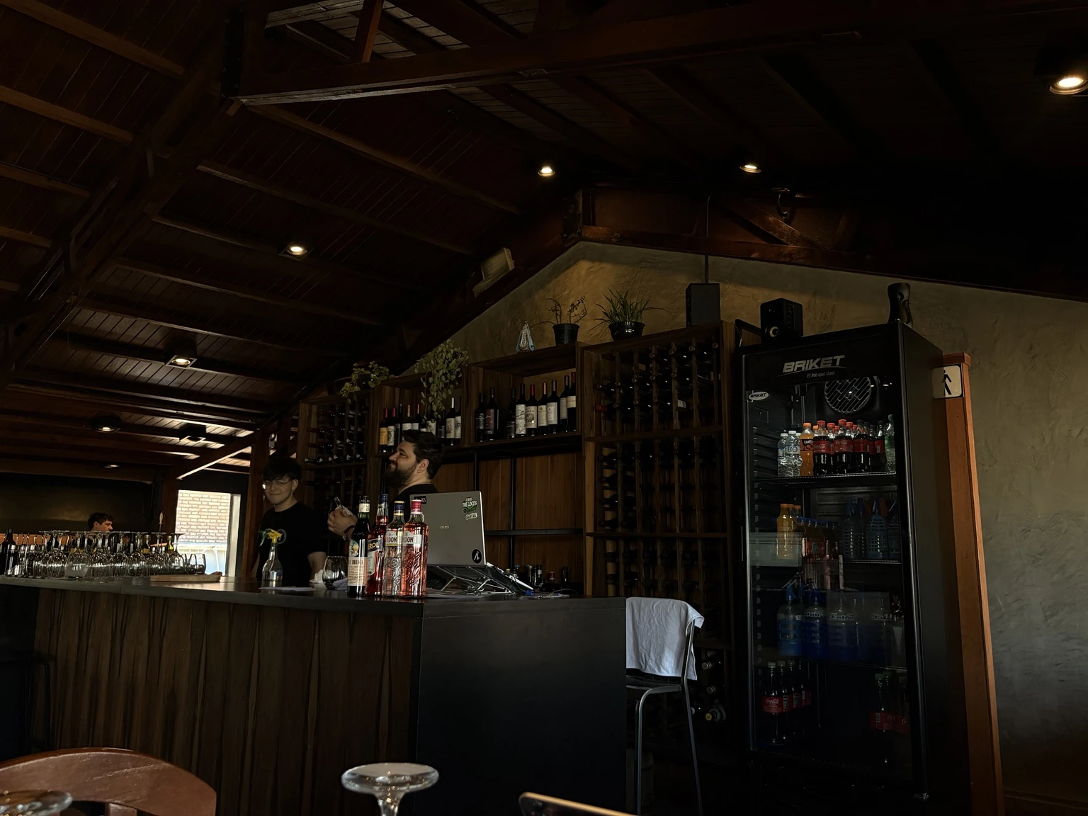 Barra de madera de Herencia con cava de vinos y equipo atendiendo